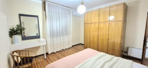 een slaapkamer met een bed, een ladekast en een spiegel bij Villa Due Cieli 1 in Lanzo dʼIntelvi