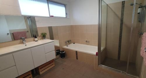 ein Badezimmer mit Dusche, Waschbecken und Badewanne in der Unterkunft Sensational Waterfront Apartment in Dunbogan