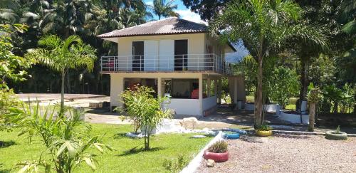 een huis met een balkon en een tuin met bomen bij PARAISO do TOMATE in Antonina