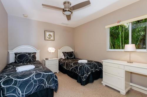 a bedroom with two beds and a desk and a window at Alecia in Cape Coral