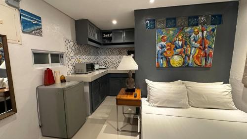Eine Küche mit einem Gemälde an der Wand über einem Sofa. in der Unterkunft Beach Apartment Studio with Kitchen in Boracay
