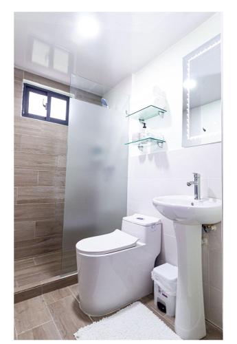 a white bathroom with a toilet and a sink at Caribbean Breeze in Punta Cana