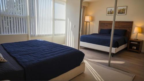 a bedroom with a blue bed and a mirror at Resort-Style Family Getaway in Santa Monica in Los Angeles