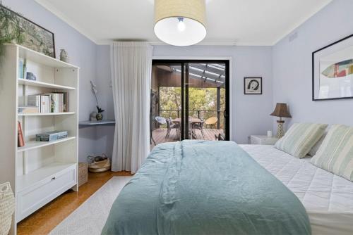 a bedroom with a large bed and a window at Treehouse at Cape in Cape Paterson