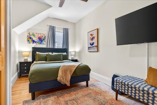Un dormitorio con una cama, un televisor y un sofá. en Charming 1BR Steps from Church Street - Downtown, en Burlington