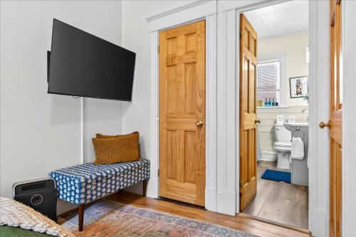 Una habitación con un televisor, una silla y una puerta. en Charming 1BR Steps from Church Street - Downtown, en Burlington