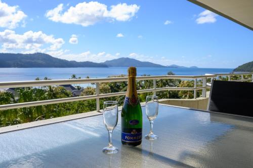 Una botella de vino sobre una mesa con dos copas de vino. en Poinciana Lodges, en Hamilton Island