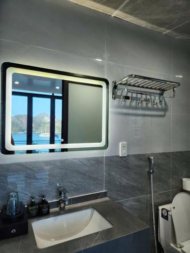a bathroom with a sink and a mirror at Sunrise Ocean Hotel & Rooftop Bar in Cat Ba