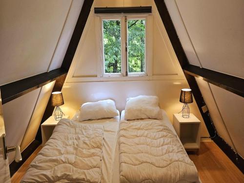 um quarto com uma cama e uma janela em Relaxing Ardennes Getaway in Durbuy em Septon