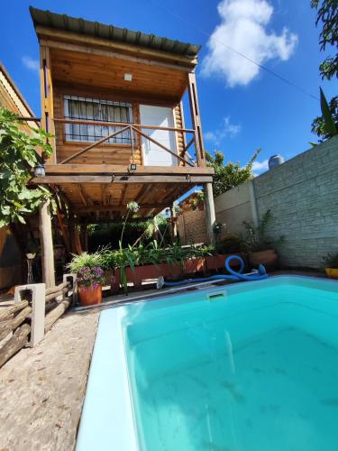 een huis met een zwembad en een terras bij Dormís La Cabaña in San Antonio de Areco