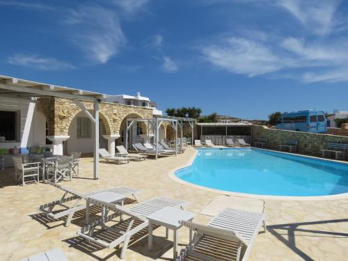 una gran piscina con sillas y una mesa en Paradise Hotel, en Koufonisia