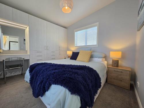 a bedroom with a bed with a blue blanket on it at Time Out in Pohara in Pohara