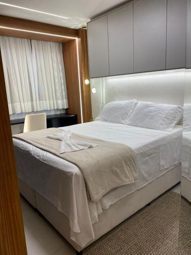 a bedroom with a large bed with white sheets at Studio beach class Meireles in Fortaleza
