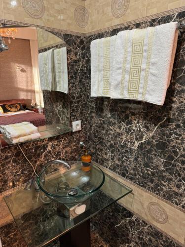 a bathroom with a glass sink and a mirror at Diamond Hotel in Chişinău