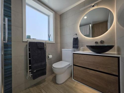 a bathroom with a sink and a toilet and a mirror at Time Out in Pohara in Pohara