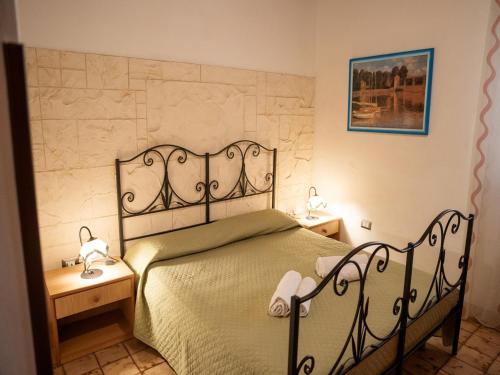 a bedroom with a bed and two night stands at Spacious villa with a large veranda and pool in Floridia