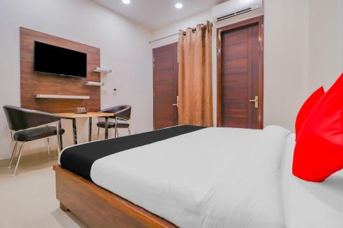 ein Schlafzimmer mit einem Bett und einem Tisch mit Stühlen in der Unterkunft Hotel O by OYO Crystal Empire in Zirakpur