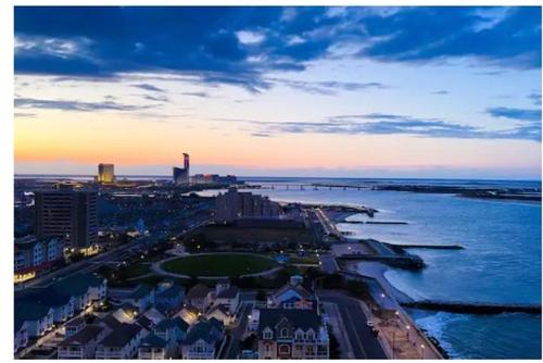 an aerial view of a city and the ocean at sunset at Serenity Escapes Waterfront Atlantic City Condo with Balcony & Free Parking in Atlantic City