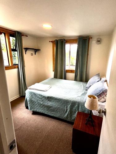 a bedroom with a bed with a laptop on it at Cabaña en el bosque, Valdivia in Valdivia