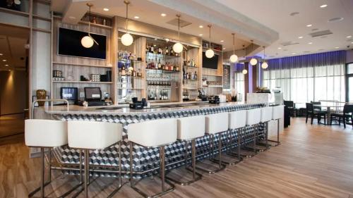 a bar in a restaurant with white bar stools at Serenity Escapes Waterfront Atlantic City Condo with Balcony & Free Parking in Atlantic City