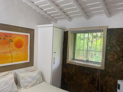 a bedroom with a bed and a window at Pousada Mirante do Atalaia - Praia da Escadaria - Arraial do Cabo in Arraial do Cabo
