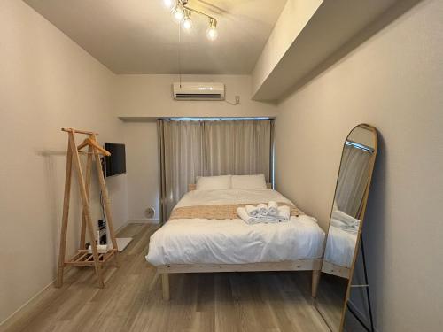 a bedroom with a bed and a mirror in it at P-Stay広島富士見町302 in Hiroshima