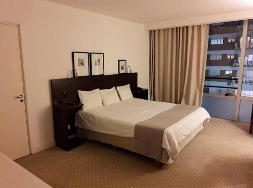 Mar de Ajó hostal في مار دي آخو: غرفة نوم بسرير كبير في غرفة فندق