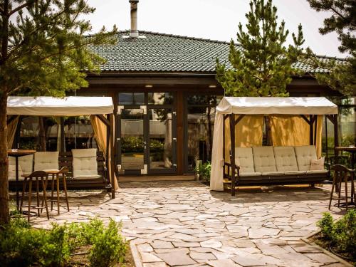 a patio with chairs and a gazebo at Rixos Borovoe in Borovoye