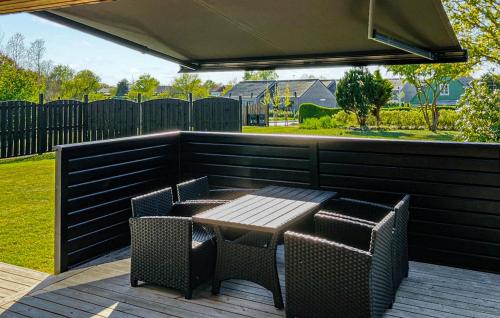 Un patio con una mesa y sillas en una terraza. en Cozy Home In Samsø With Kitchen, en Onsbjerg