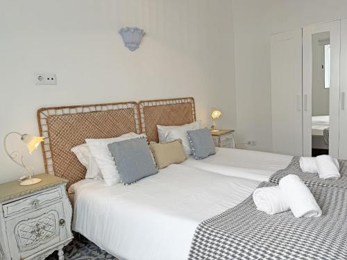 een slaapkamer met 2 bedden met witte lakens en blauwe kussens bij Casa Florence - Fuseta in Fuzeta