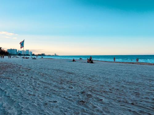 un gruppo di persone su una spiaggia con una bandiera di Ocean View Apartment inside ESJ Hotel a San Juan