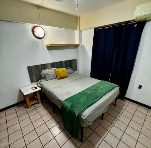 een slaapkamer met een bed met een geel kussen erop bij Habitación en Depto chic compartido in Villahermosa