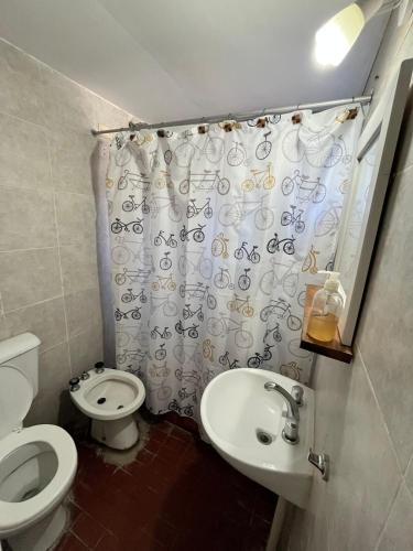 Un baño con inodoro, lavabo y cortina de ducha. en Zakk Casa de Playa, en Necochea