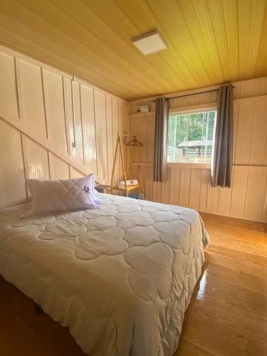 a bedroom with a bed in a room with a window at Chácara Leopoldo Bairro in Lages
