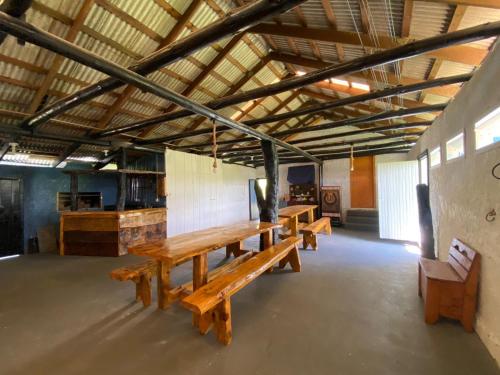 un gruppo di panche di legno in una grande stanza di Chácara Leopoldo Bairro a Lages