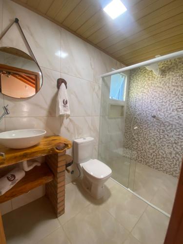 a bathroom with a toilet and a sink and a shower at Chácara Leopoldo Bairro in Lages