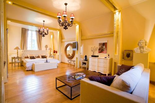 a living room with a couch and a table at Chateau-Hotel De Belmesnil in Saint-Denis-le-Thiboult