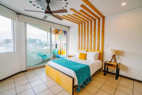 Un dormitorio con una cama y una ventana grande. en Mayan Monkey Los Cabos - Social Hotel, en Cabo San Lucas