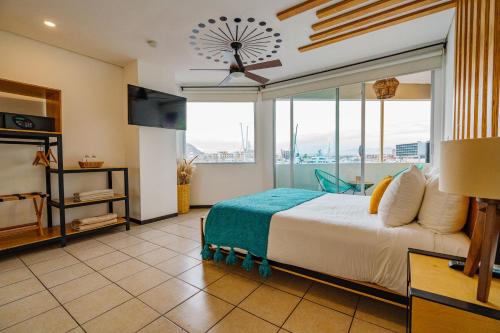 カボ・サン・ルーカスにあるMayan Monkey Los Cabos - Social Hotelの大きなベッドと大きな窓のある寝室