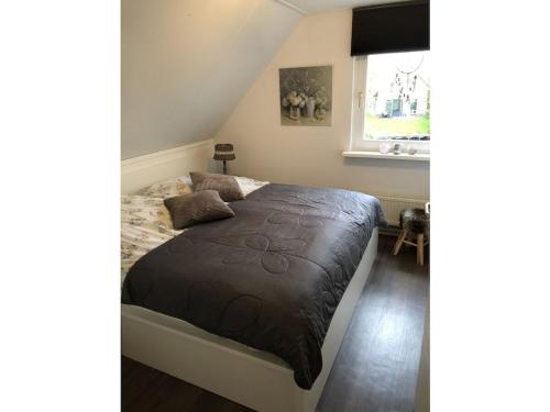 a bedroom with a bed with a brown blanket at Holiday home with 1 bedroom in Medemblik