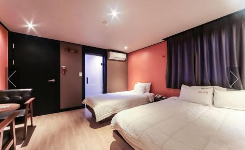 une chambre d'hôtel avec deux lits, une chaise et un bureau dans l'établissement Nampo Foxy Hotel, à Busan