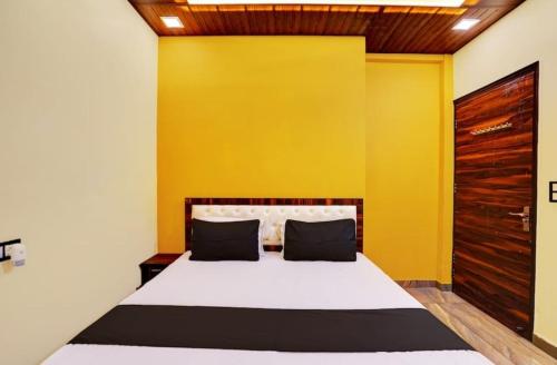 a bedroom with a bed with a yellow wall at Hotel Royal Vista in Meerut