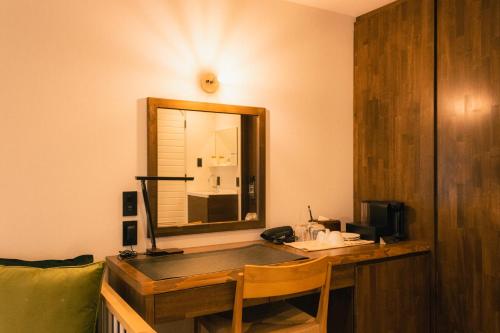 a desk in a room with a mirror and a telephone at BUB RESORT Yatsugatake in Hokuto