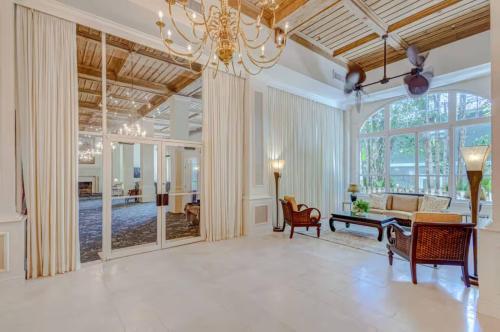 a large living room with a large chandelier at Palm Beach Condo 5 Mins to Beach Heated Pool in Palm Beach