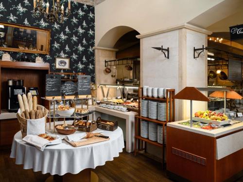 Una panadería con una mesa con comida encima. en Mercure Szekesfehervar Magyar Kiraly, en Székesfehérvár
