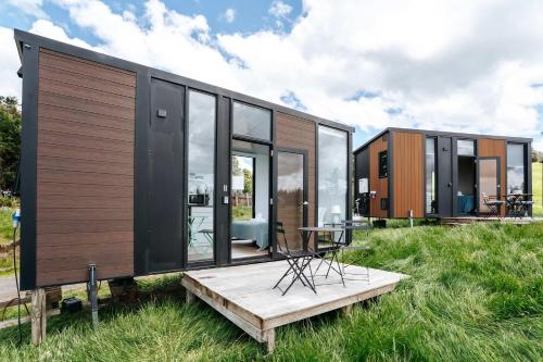 a tiny house sitting on top of a field at Aorangi Peak Cabins 8 by Tiny Away in Rotorua