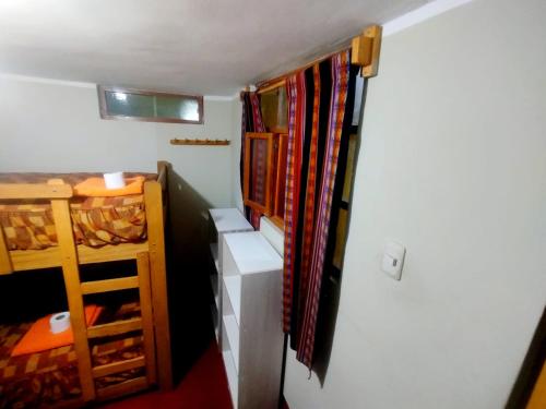 ein kleines Zimmer mit einem Kleiderschrank und einem Etagenbett in der Unterkunft Andes Hostel in Huaraz