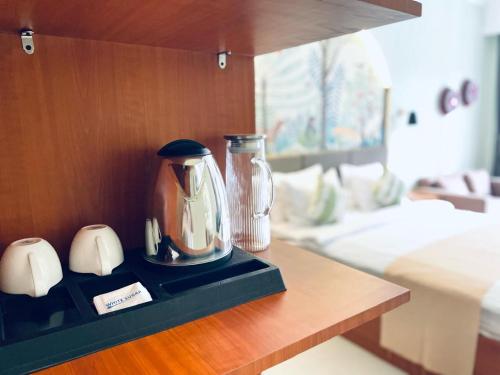 ウブドにあるDewangga Suiteの寝室のテーブルに置かれたアフィーポットとコーヒーポット