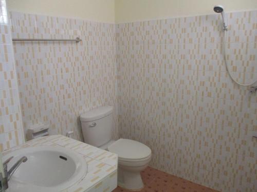 a bathroom with a white toilet and a shower at The Prince Residence , Weekly Stay Chiang Rai in Chiang Rai