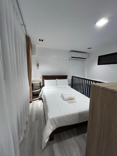 a bedroom with two beds with white sheets at Tim's Guest House in Butuan